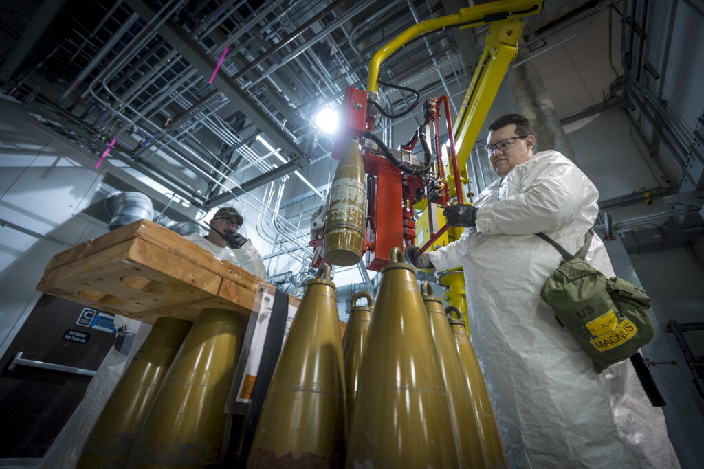 A Pueblo Chemical Agent-Destruction Pilot Plant Ordnance Technician uses a lift assist to load Assembled Chemical Weapons Alternatives (ACWA) Test Equipment, or ATE, onto a conveyor for further processing in the Explosion Containment Room in the Enhanced Reconfiguration Building.