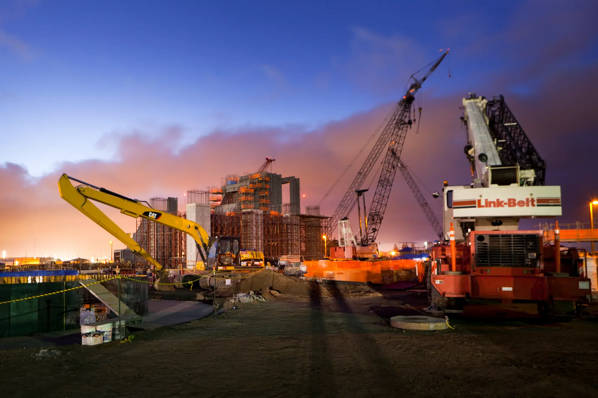 Dusk shot of the Russell City site with a variety of excavators, cranes and light plants in operation with heat recovery steam generator (HRSG) units in the background.