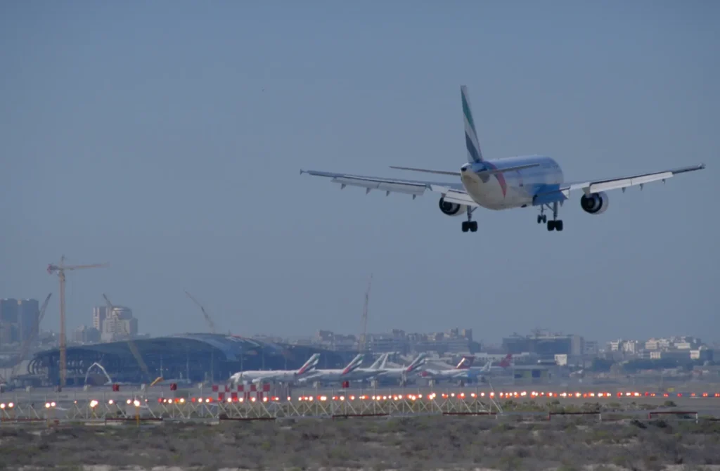An airplane takes off from Dubai International Airport. Construction of the extension is seen in the background.