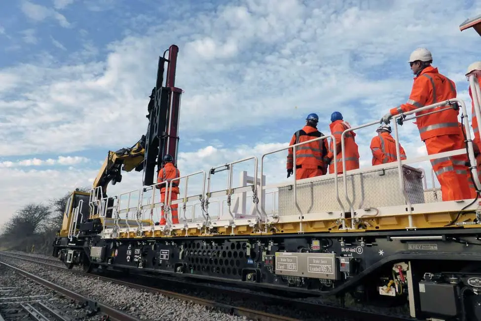 Project crew pictured using heavy machinery on train tracks.