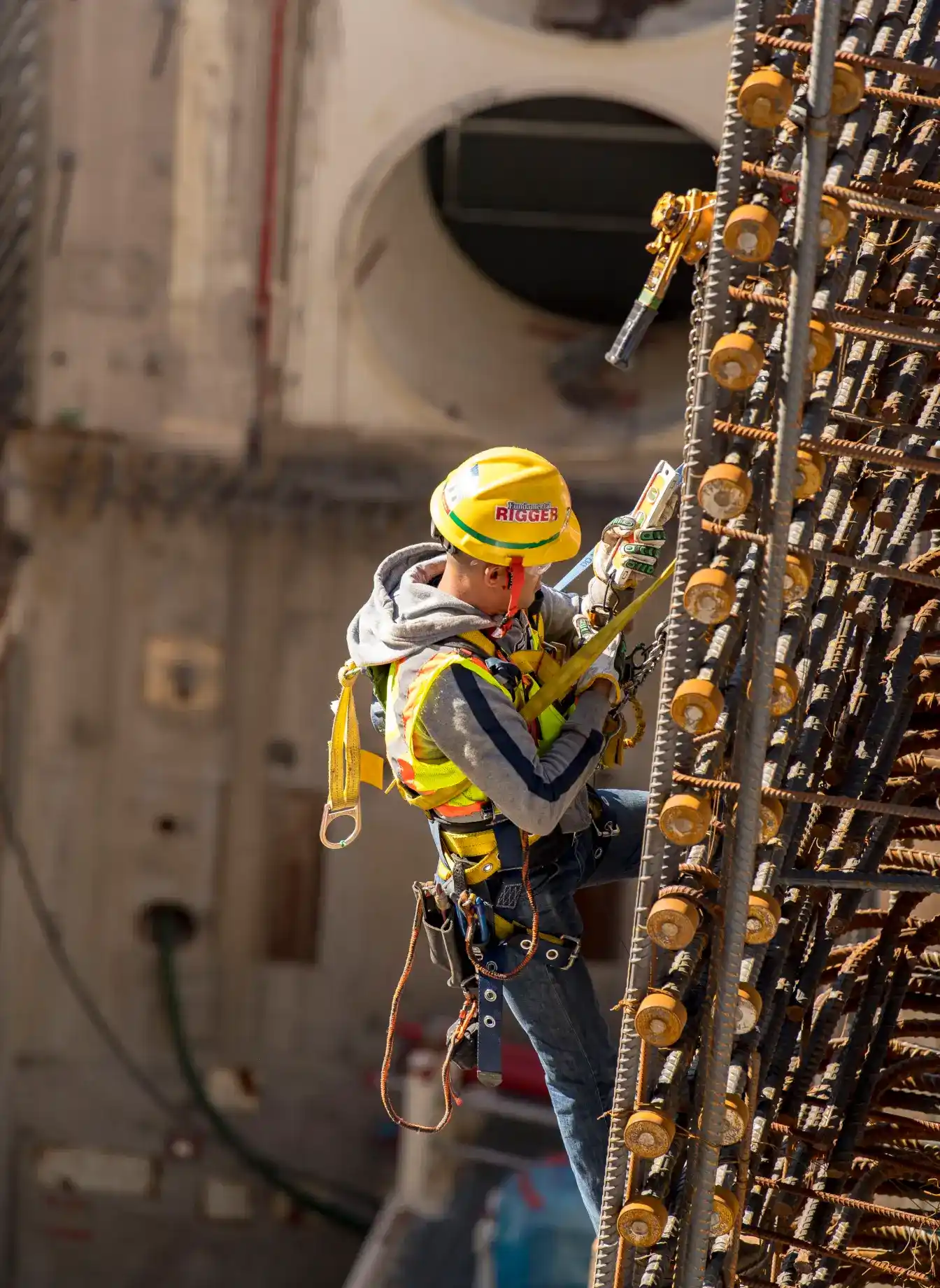Construction worker suspended from rebar to complete the work.